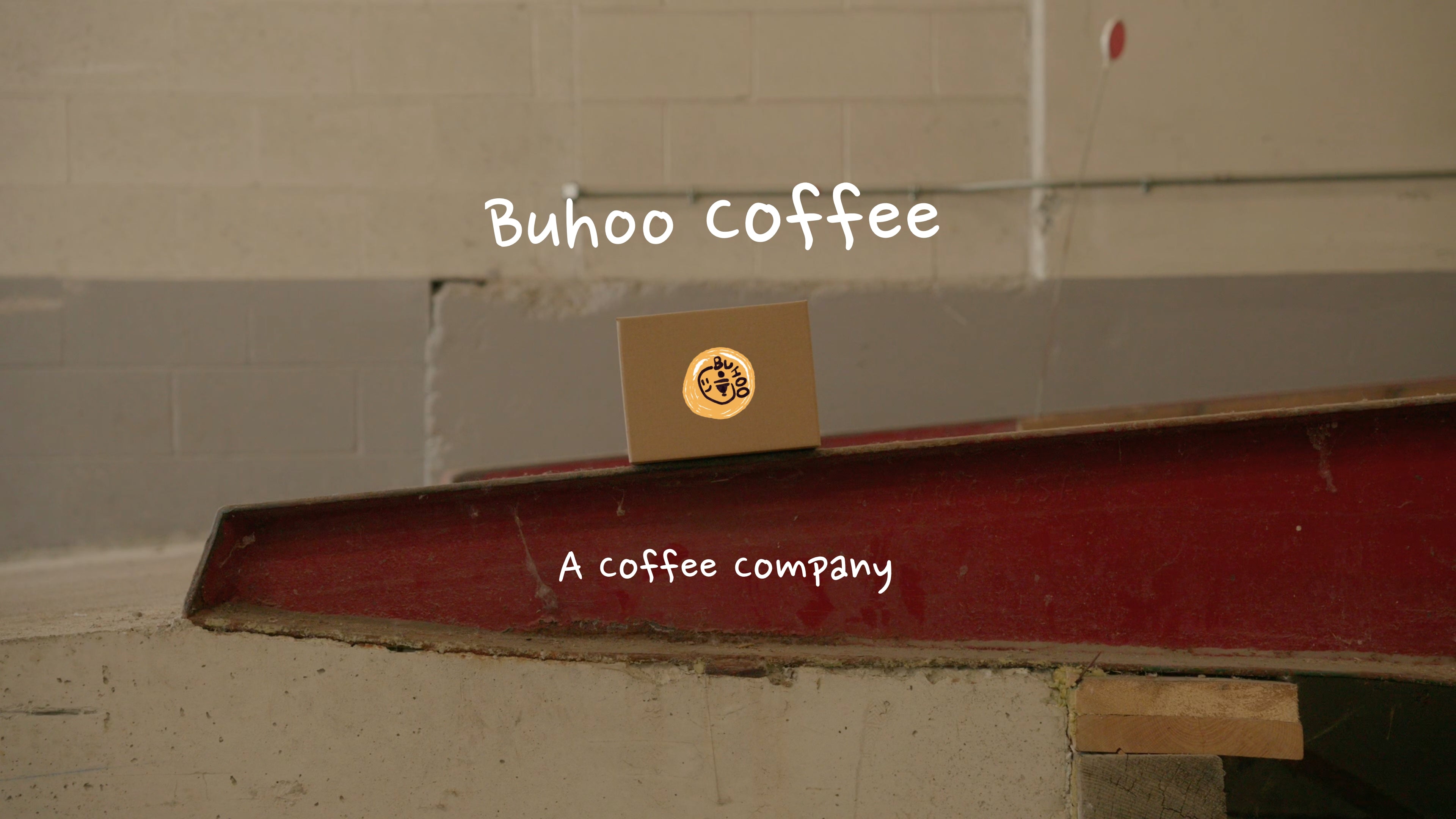 Buhoo coffee logo on a cardboard box against a beige wall.